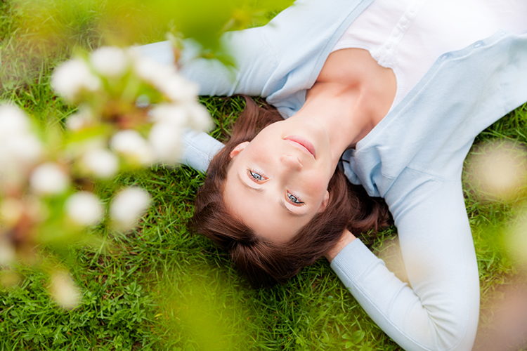 Frau liegt auf der Wiese